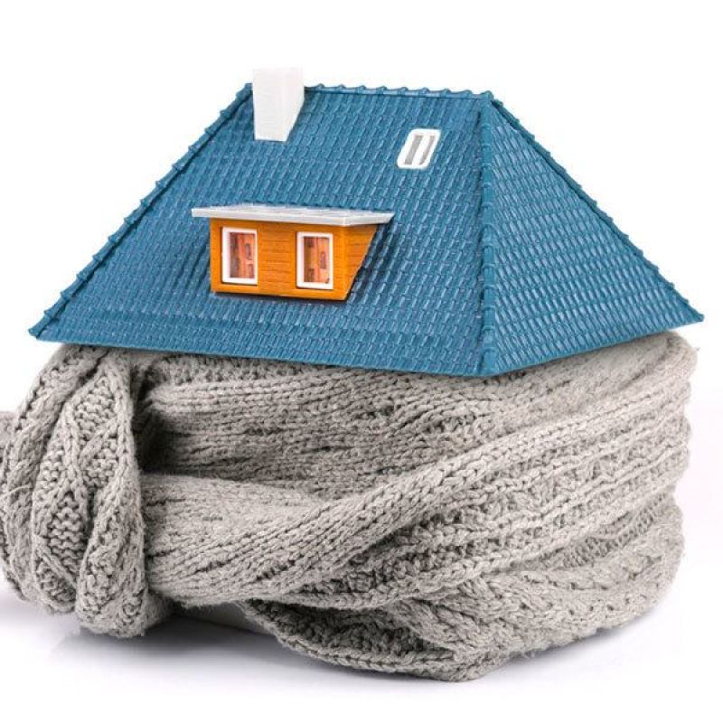 House model wrapped in a gray knitted scarf, symbolizing home insulation and energy efficiency.