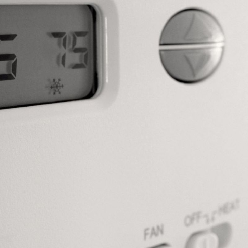 Digital thermostat displaying 75 degrees Fahrenheit, featuring cooling mode symbol, close-up view.