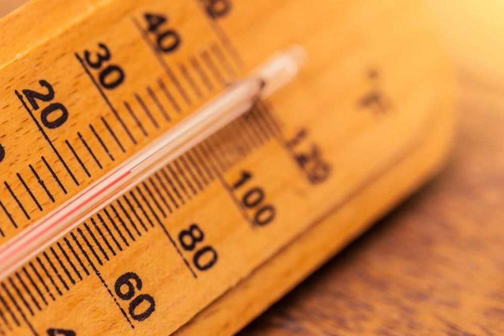 Close-up of a thermometer showing temperature in Fahrenheit and Celsius, highlighting warm climate conditions.